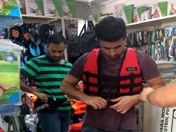 Refugiado comprando un chaleco salvavidas