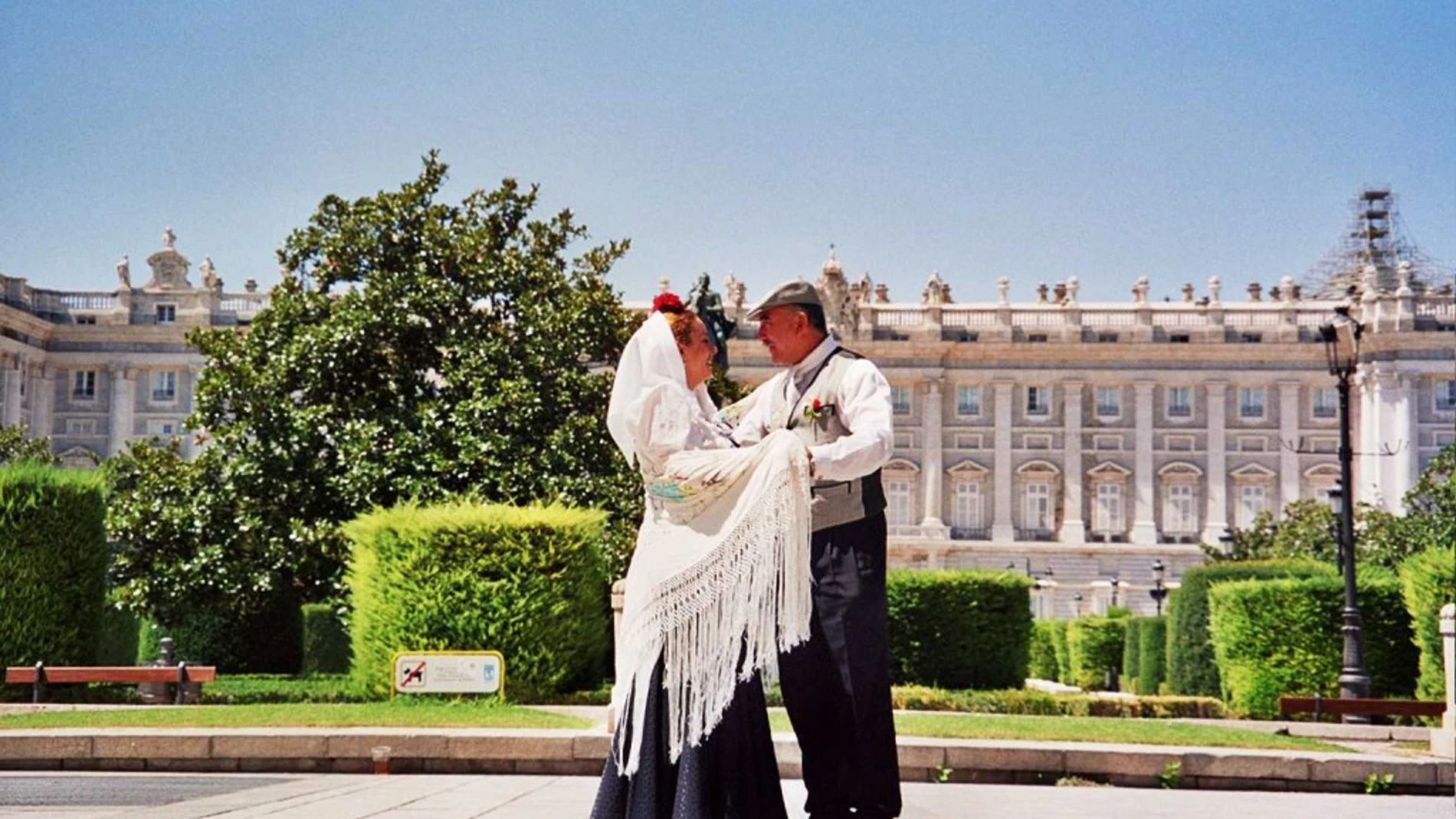 Dos personas bailan el tradicional chotis madrileño frente al Palacio Real de Madrid. Dos personas bailan el tradicional chotis madrileño frente al Palacio Real de Madrid.