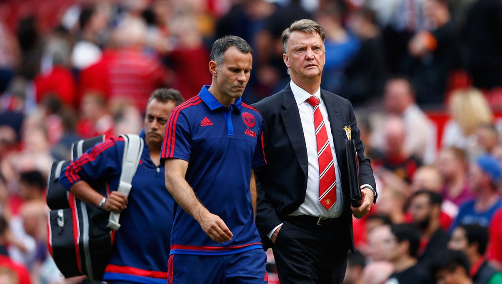 Van Gaal se dirige al banquillo de Old Trafford junto con Giggs