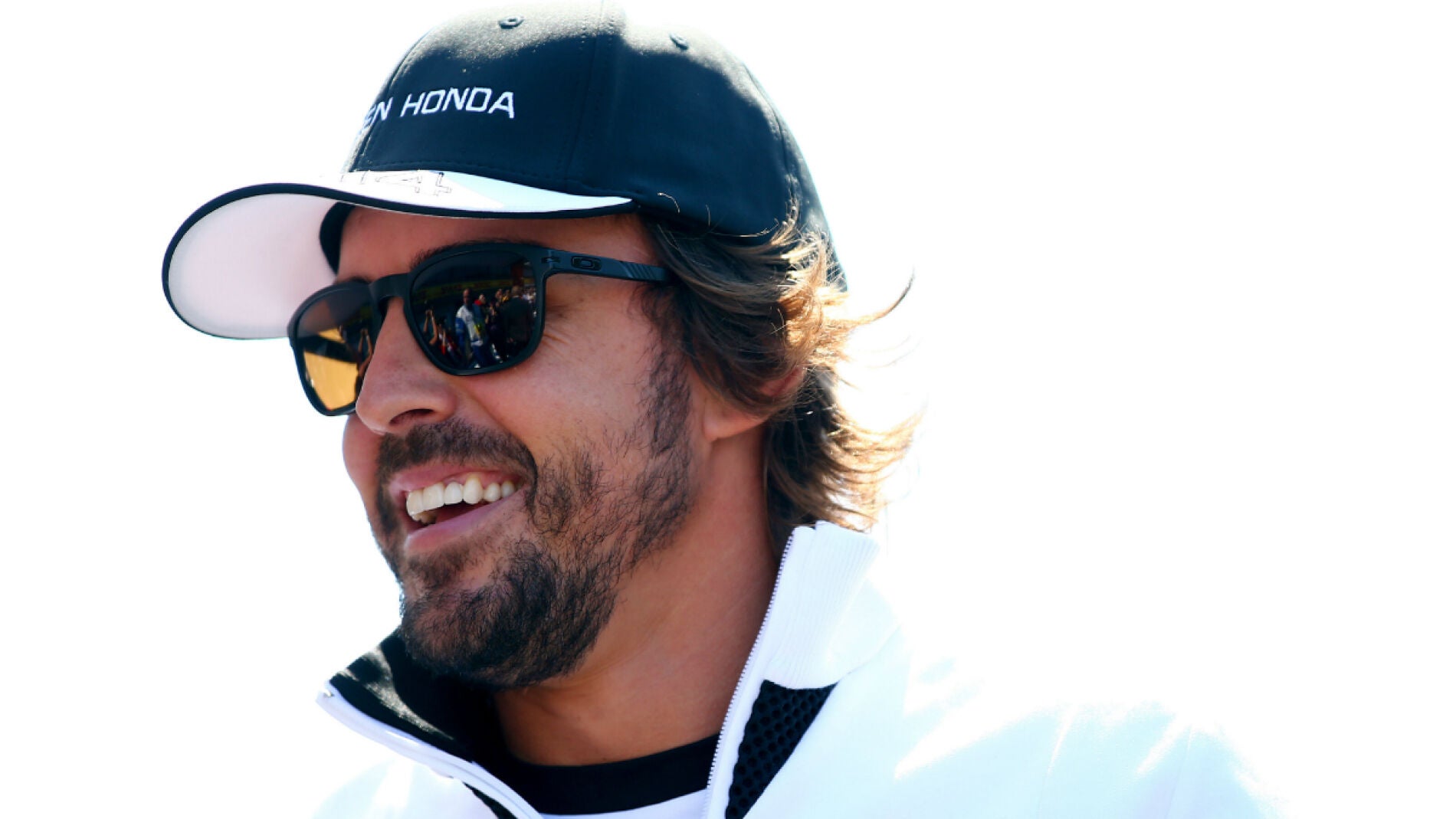 Alonso sonr&iacute;e en el paddock