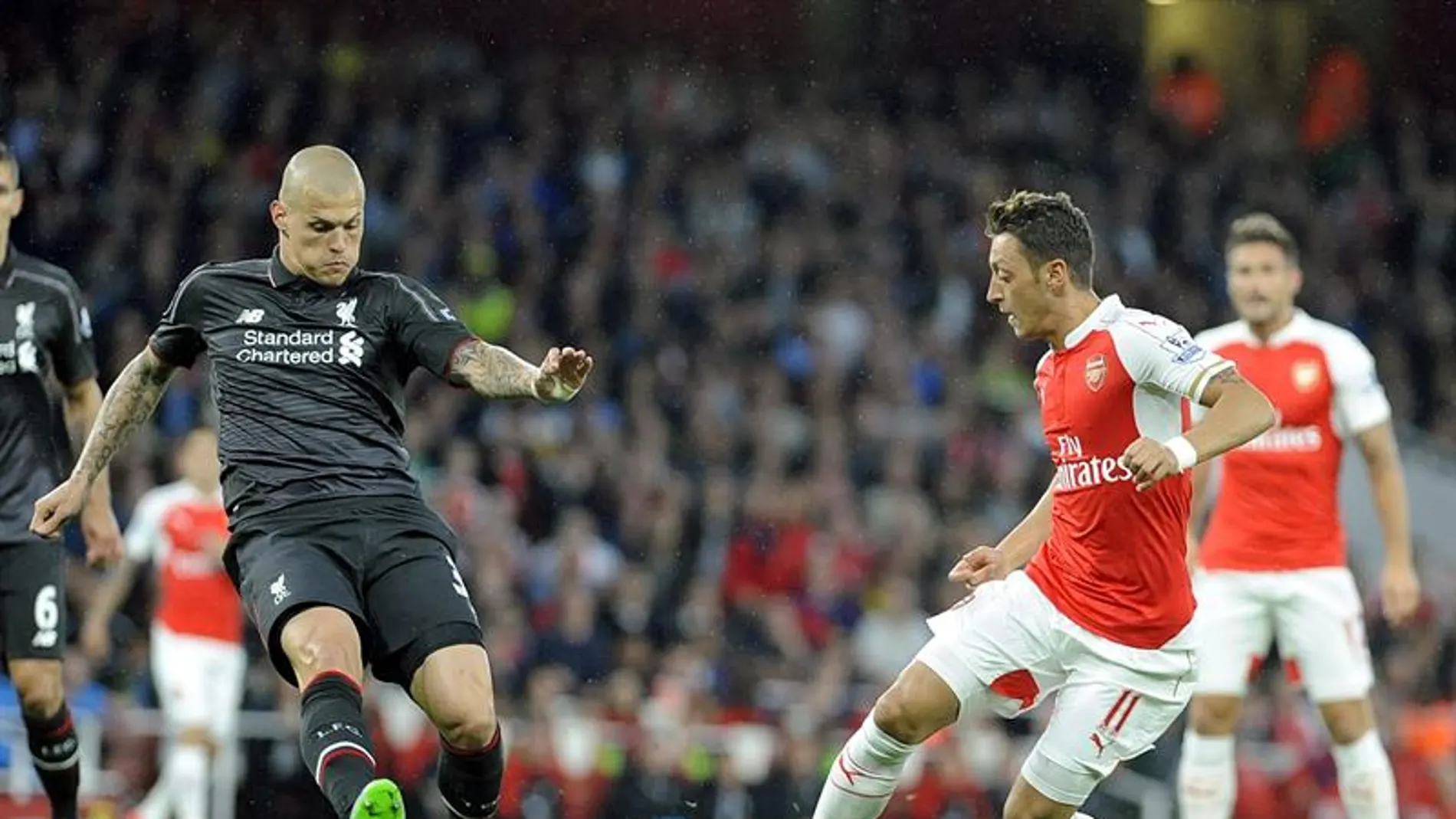 Mesut Özil disputa el balón con Martin Skrtel Mesut Özil disputa el balón con Martin Skrtel