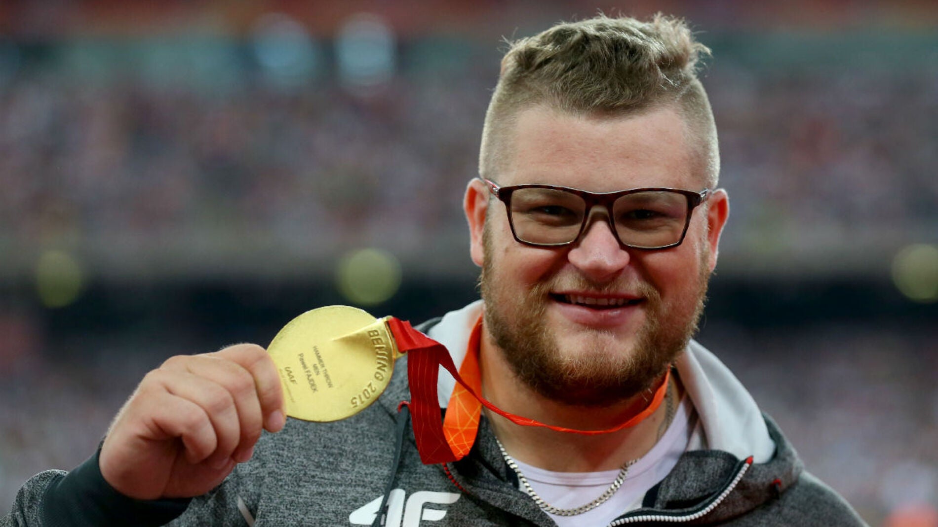 Pawel Fajdek posa sonriente con su medalla de oro en Pek&iacute;n