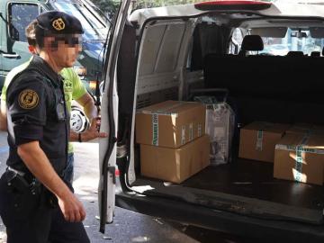 Agentes de la Guardia Civil retiran el material recogido durante el registro efectuado en la sede de la fundación CatDem de CDC.