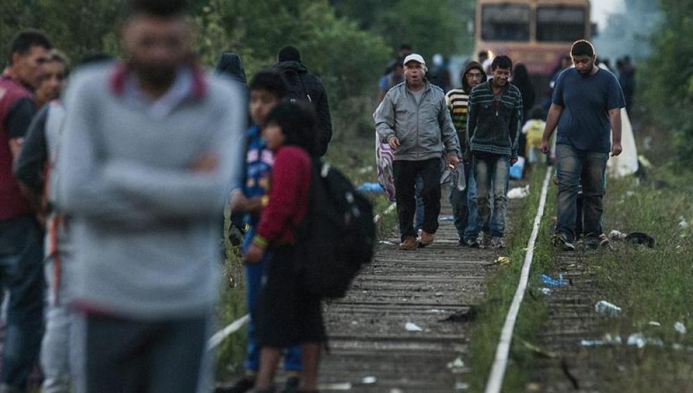 Inmigrantes caminan sobre las vías de un tren en la frontera entre Hungría y Serbia 