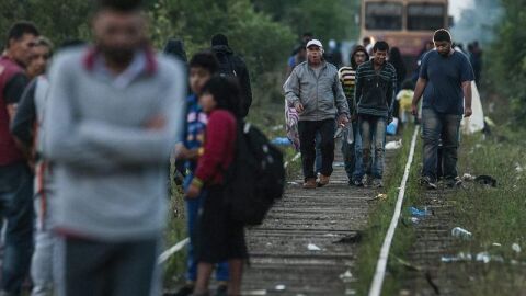 Inmigrantes caminan sobre las v&iacute;as de un tren en la frontera entre Hungr&iacute;a y Serbia 