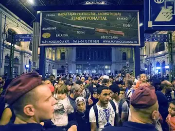 Inmigrantes esperan para subir al tren que les lleve a Alemania. Inmigrantes esperan para subir al tren que les lleve a Alemania.