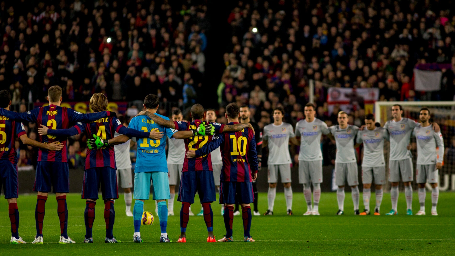 Jugadores del Atl&eacute;tico de Madrid y FC Barcelona, guardando un minuto de silencio