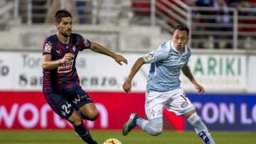  El centrocampista del Eibar Adrián (i) pelea un balón con el chileno Orellana, del Celta de Vigo