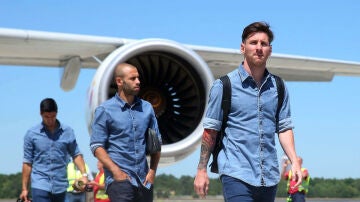 Mascherano camina por detrás de Messi en un aeropuerto