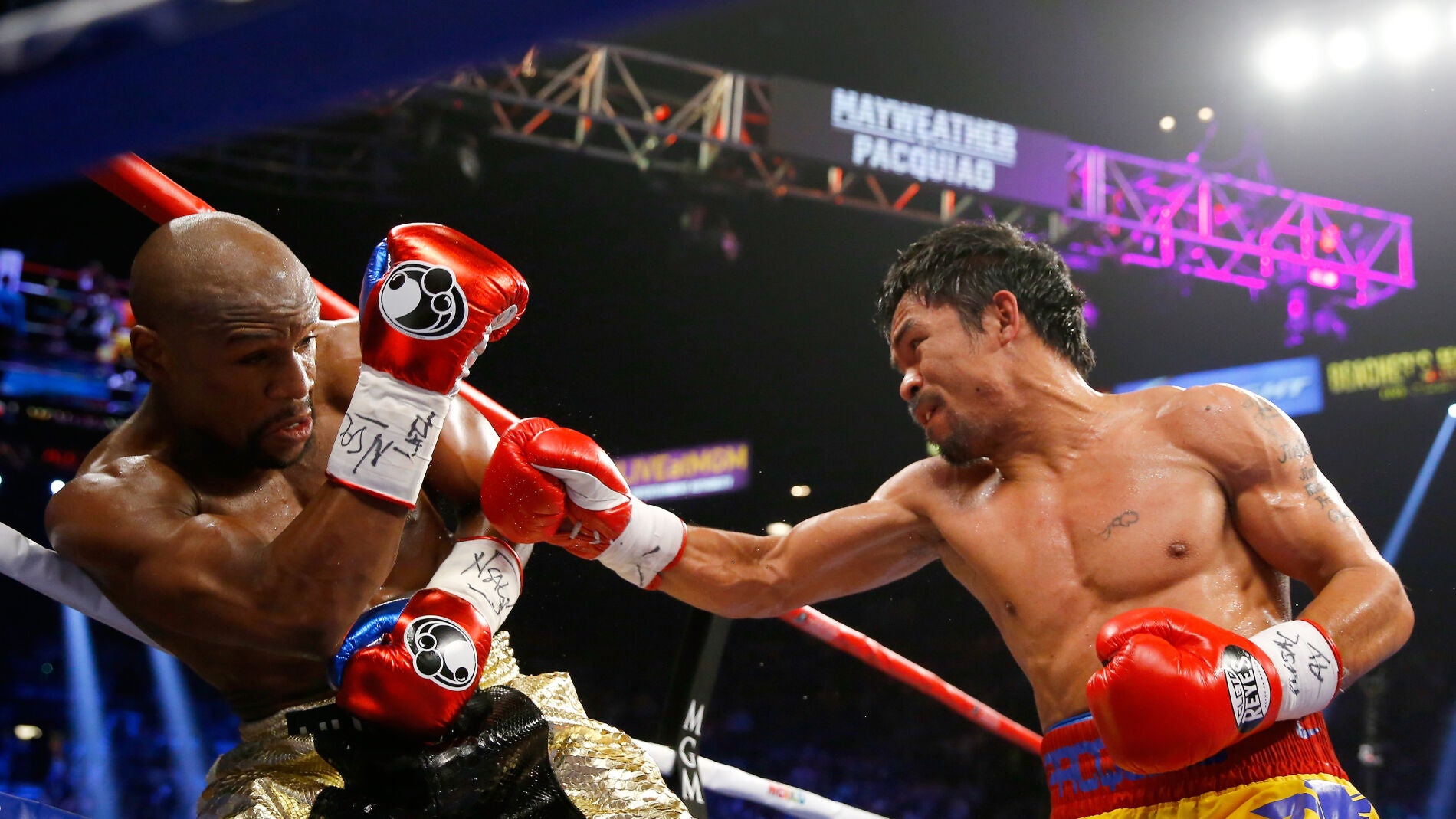 Manny Pacquiao (d) lanza un pu&ntilde;etazo a Floyd Mayweather (izq)
