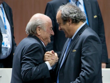 Joseph Blatter y Michel Platini se saludan