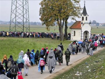 Refugiados se dirigen a centros de acogida en la frontera con Croacia en Rigonce (Eslovenia)