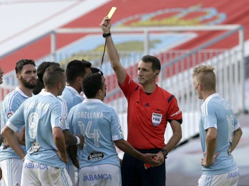 Clos Gómez muestra una tarjeta a un jugador del Celta