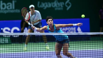 Carla Suárez ataca una bola en la red ante la mirada de Muguruza