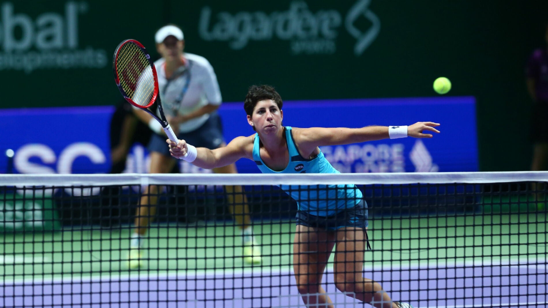 Carla Su&aacute;rez ataca una bola en la red ante la mirada de Muguruza