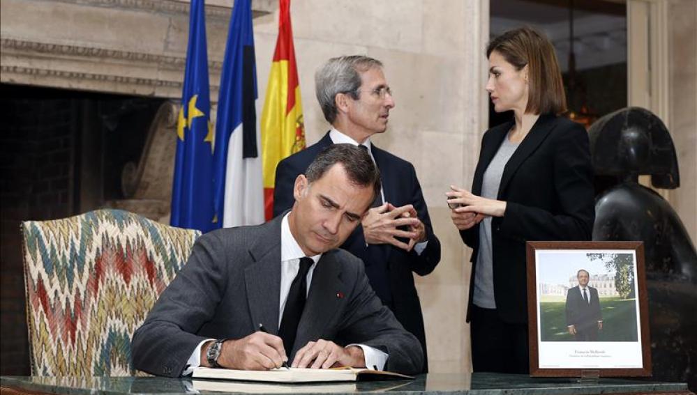 La Reina Letizia conversa con el embajador francés, Yves Saint-Geours, mientras el Rey Felipe VI firma en el libro de condolencias