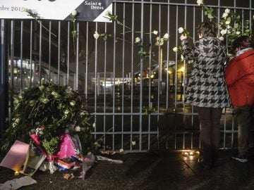 Varias personas depositan flores en homenaje a las víctimas en el Estadio de Francia