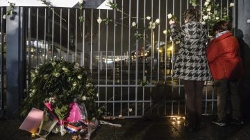 Varias personas depositan flores en homenaje a las víctimas en el Estadio de Francia