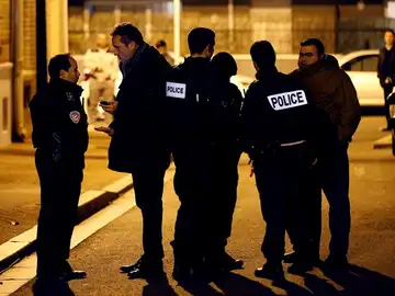 Oficiales de policía prestan guardia en una calle cerca de París Oficiales de policía prestan guardia en una calle cerca de París