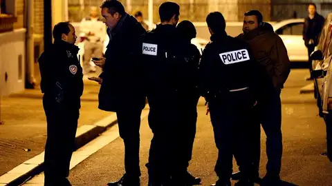 Oficiales de policía prestan guardia en una calle cerca de París Oficiales de policía prestan guardia en una calle cerca de París