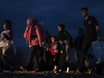 Varios refugiados caminan hacia un campamento de registro y tránsito Varios refugiados caminan hacia un campamento de registro y tránsito