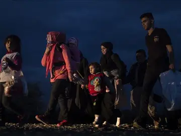 Varios refugiados caminan hacia un campamento de registro y tránsito Varios refugiados caminan hacia un campamento de registro y tránsito