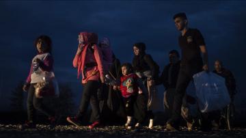 Varios refugiados caminan hacia un campamento de registro y tránsito