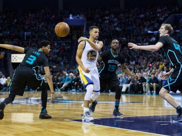 Stephen Curry realiza un pase sin mirar ante los Hornets