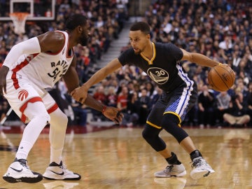 Stephen Curry conduce el balón ante la defensa de Patrick Patterson