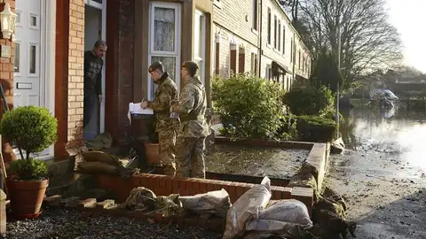 Soldados conversan con un residente por las inundaciones Soldados conversan con un residente por las inundaciones