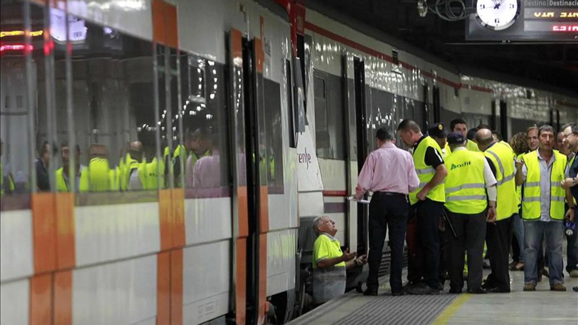 Trabajadores de RENFE revisan un tren en un andén de una estación en Barcelona. Trabajadores de RENFE revisan un tren en un andén de una estación en Barcelona.