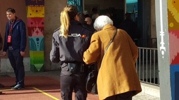 Una anciana acompañada de un agente de policía