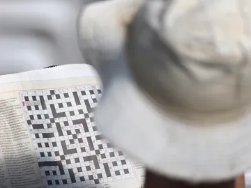 Hombre haciendo un crucigrama Hombre haciendo un crucigrama