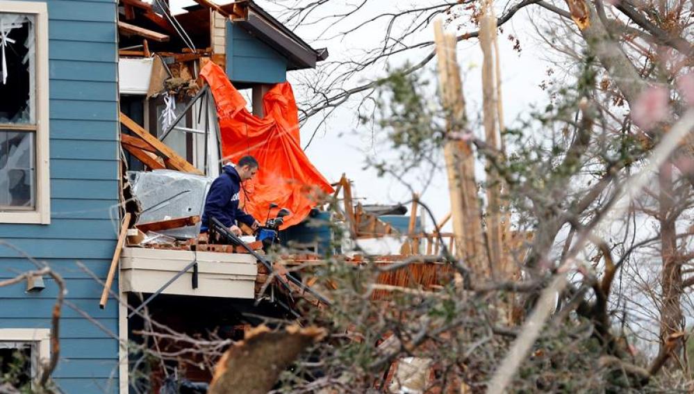 Un hombre recoge sus pertenencias en una casa destrozada