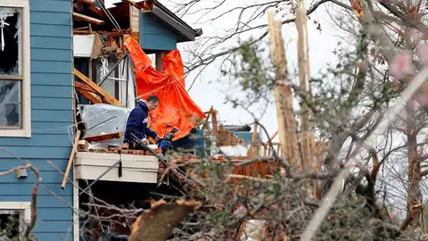 Un hombre recoge sus pertenencias en una casa destrozada Un hombre recoge sus pertenencias en una casa destrozada