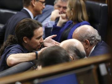 Pablo Iglesias conversa con el ministro en funciones del Interior, Jorge Fernández Díaz