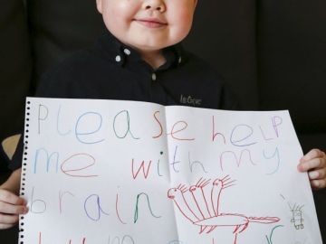 Jamie-lee Dearing con un cartel en el que pide ayuda para tratar su tumor cerebral Jamie-lee Dearing con un cartel en el que pide ayuda para tratar su tumor cerebral