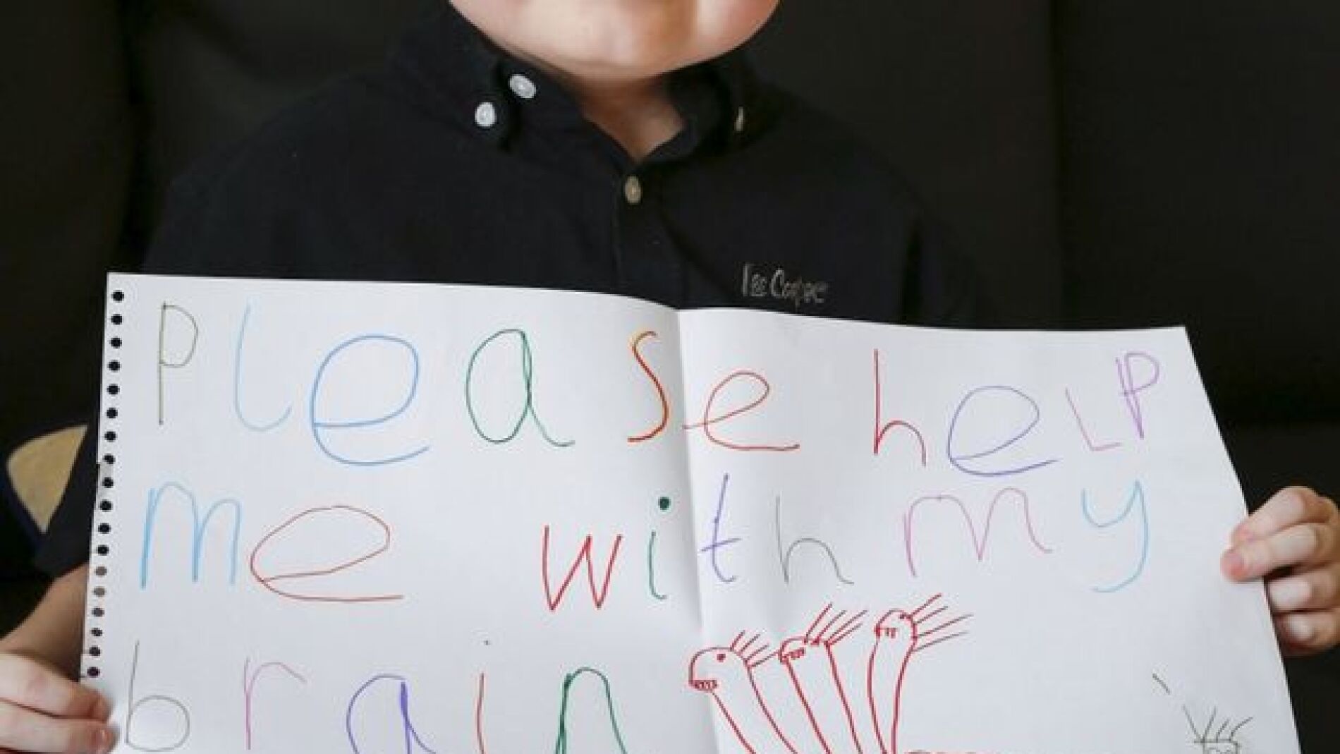 Jamie-lee Dearing con un cartel en el que pide ayuda para tratar su tumor cerebral