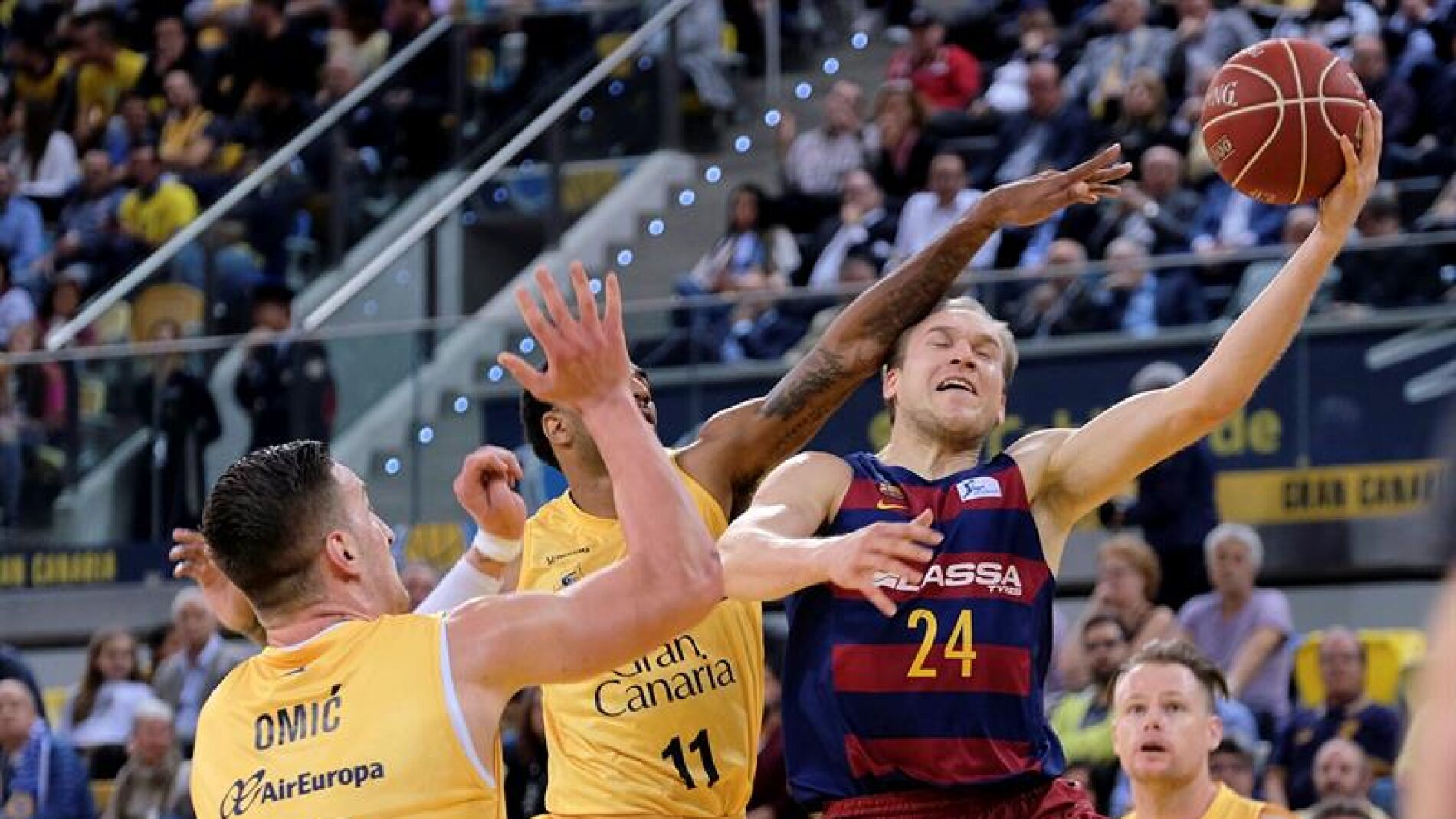 Oleson tira a canasta ante la defensa de Omic