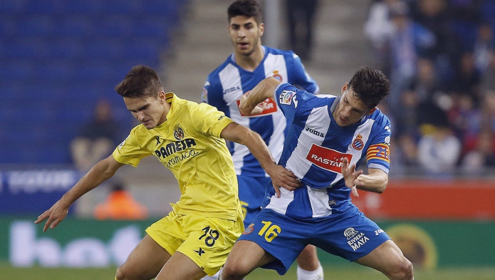 Denis Suárez lucha ante dos jugadores del Espanyol