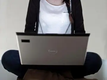 Joven utiliza un ordenador portátil Joven utiliza un ordenador portátil