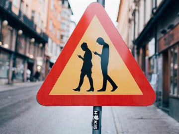 Señal Peligro peatones usando el móvil 