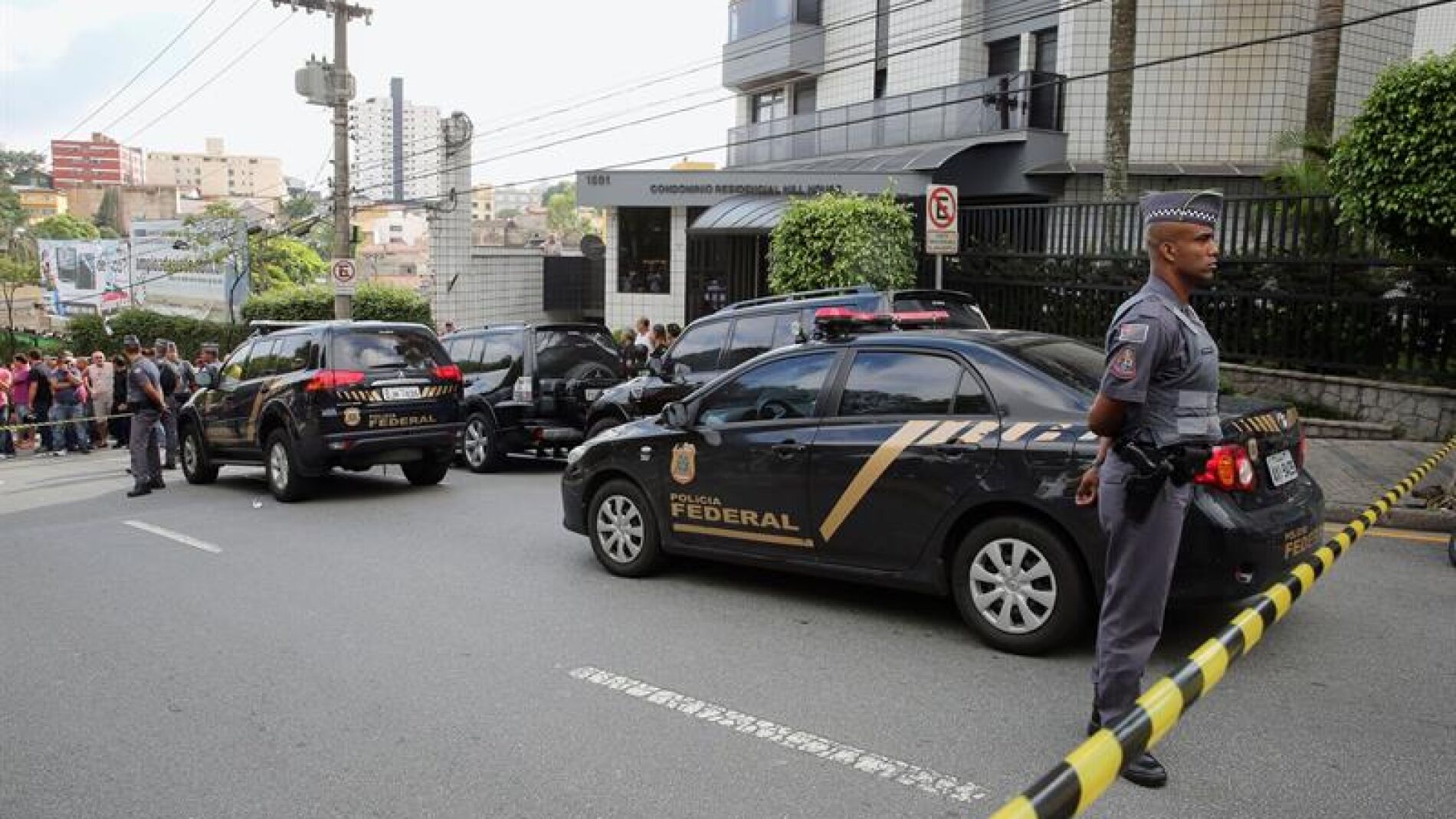 Agentes de Polic&iacute;a y curiosos ante la residencia de Lula da Silva