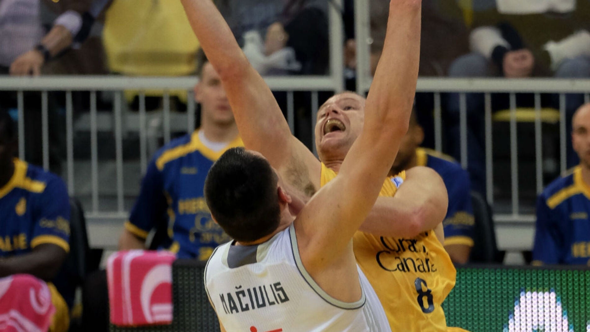 Brad Newlwy trata de encestar ante la oposici&oacute;n de Jonas Maciulis