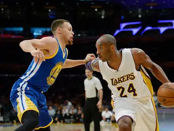Kobe Bryant conduce el balón ante la defensa de Stephen Curry Kobe Bryant conduce el balón ante la defensa de Stephen Curry