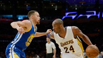 Kobe Bryant conduce el balón ante la defensa de Stephen Curry