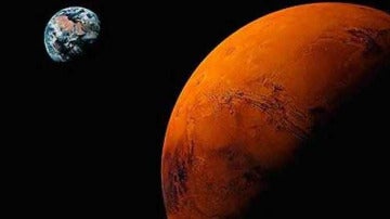 Recreación de Marte con la Tierra al fondo