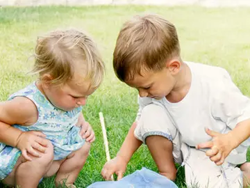 Imagen de dos niños jugando en el césped Imagen de dos niños jugando en el césped