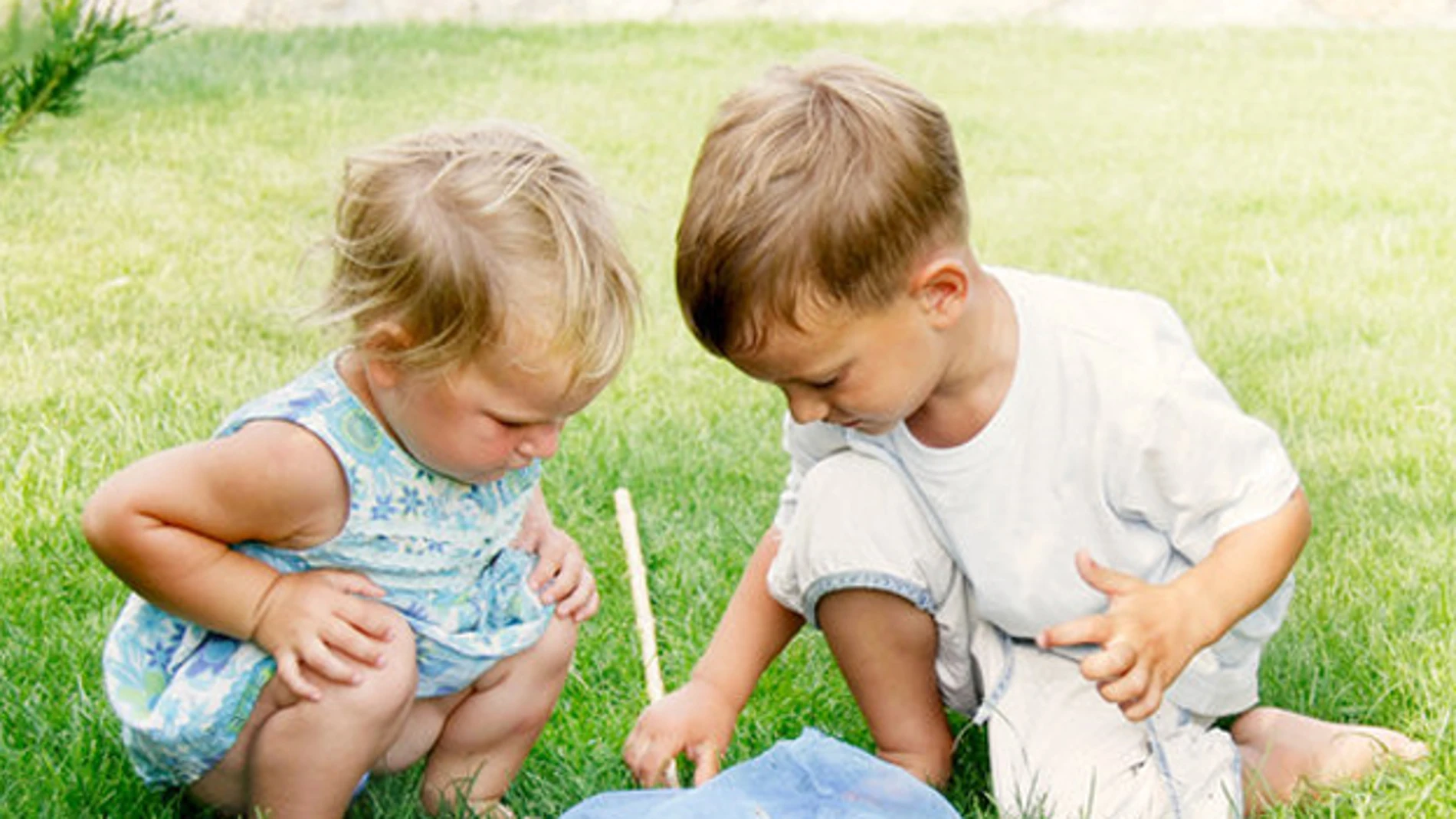 Imagen de dos niños jugando en el césped Imagen de dos niños jugando en el césped