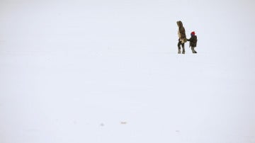 Una madre y su hijo caminan sobre la nieve